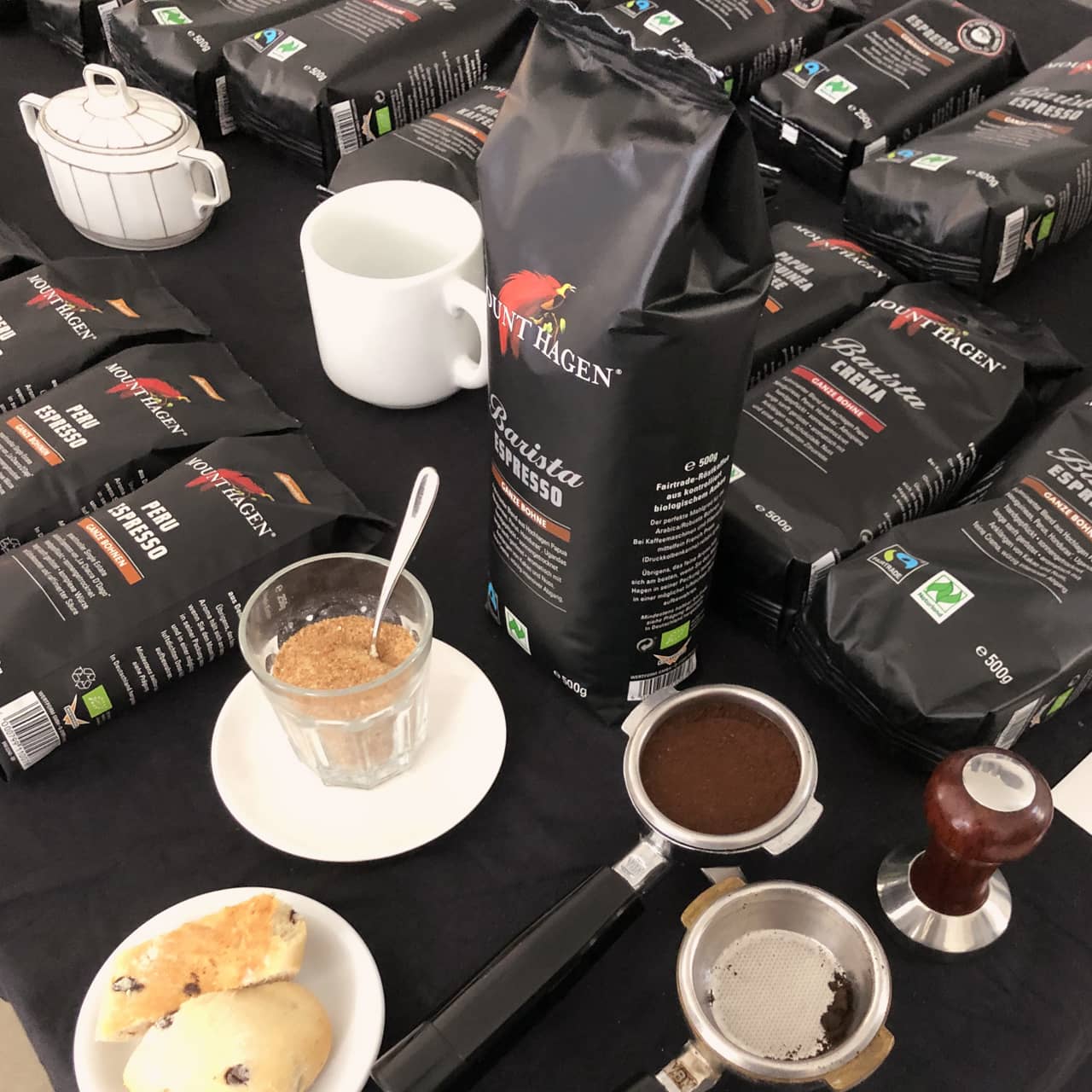 a table with bags of coffee and a cup